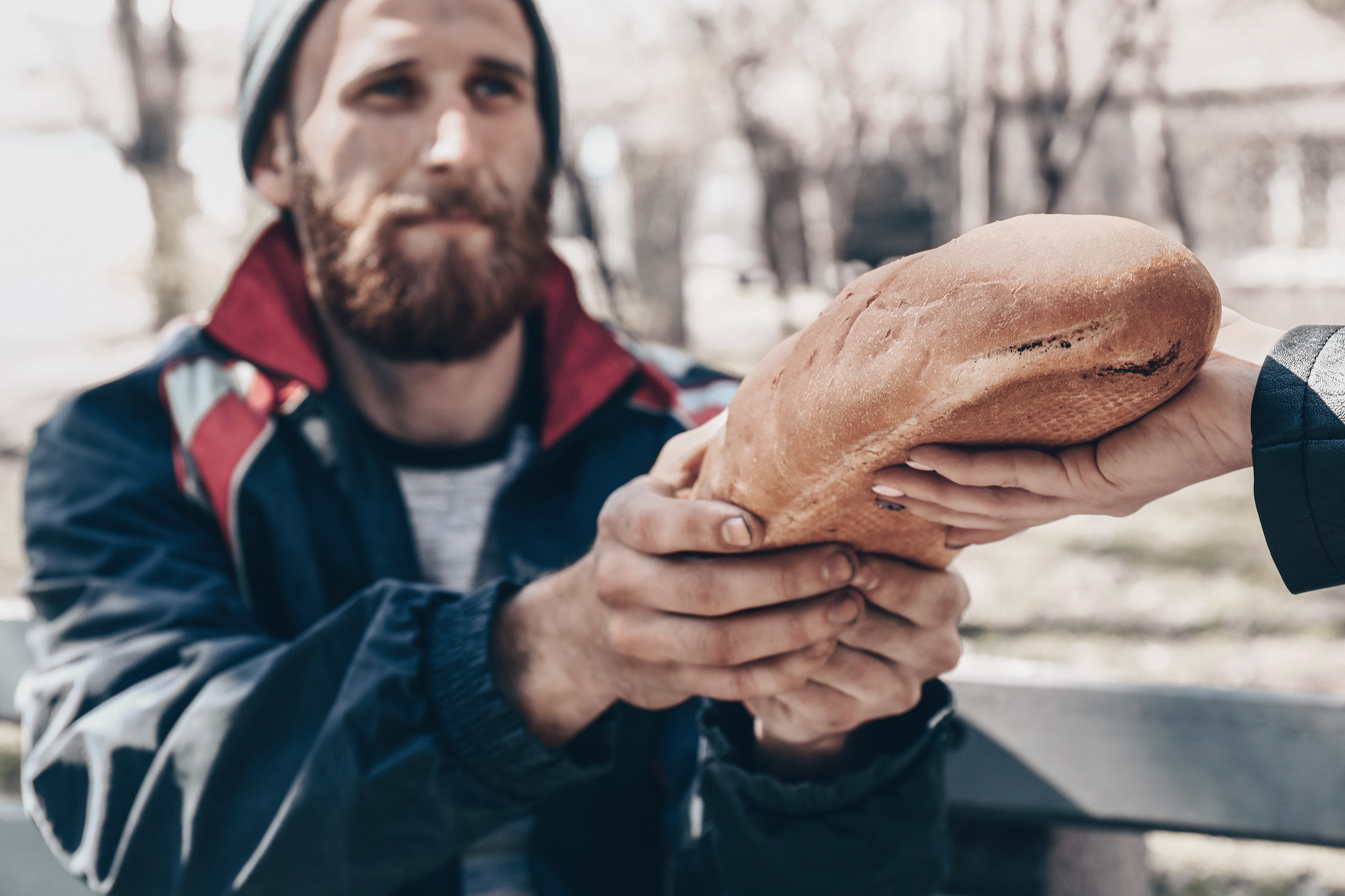 A volunteer handing a hot meal to someone at the In Touch mobile kitchen